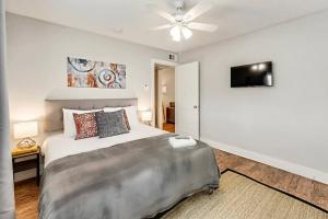 a bedroom with a large bed and a ceiling fan at Hello Gorgeous Flat near Downtown! in Dallas