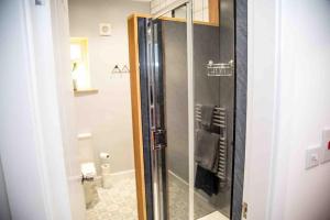 a shower with a glass door in a bathroom at Binks - Seafront 1 bed first floor apartment in Cleethorpes