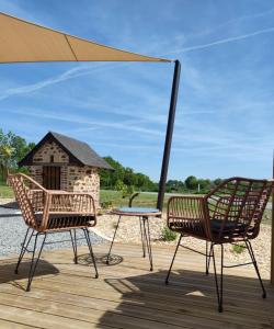 Saint-Ouen-des-ToitsにあるLa Douce Halte - Gîtes avec Spa ou Saunaの木製デッキ(椅子2脚、テーブル1台付)