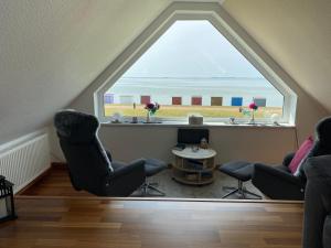 Cette chambre dispose d'une grande fenêtre offrant une vue sur la plage. dans l'établissement Jensen-Huus, à Dagebüll