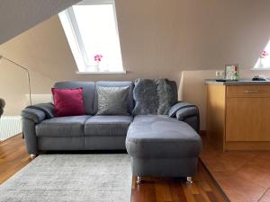 a living room with a couch and a ottoman at Jensen-Huus in Dagebüll