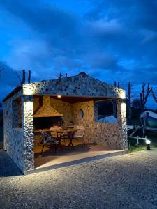 a small stone house with a table and chairs at Luxury Beach Villa in Skála +106 photos