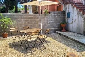 uma mesa de madeira e cadeiras com um guarda-sol em Aretina Florence Villa em Florença