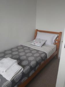 een slaapkamer met een bed met een zwart-wit dekbed bij Home in Cheltenham in Golden Valley