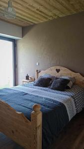 een slaapkamer met een houten bed en een blauwe deken bij LA GRANGE SAVOYARDE-Spa-Piscine-Proche lac-Charme-Détente- 3 Etoiles in Lathuile