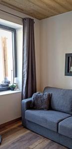 a blue couch in a living room with a window at LA GRANGE SAVOYARDE-Spa-Piscine-Proche lac-Charme-Détente- 3 Etoiles in Lathuile