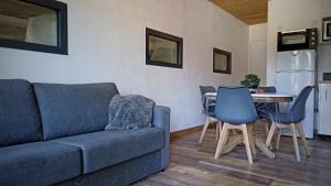 a living room with a couch and a table with chairs at LA GRANGE SAVOYARDE-Spa-Piscine-Proche lac-Charme-Détente- 3 Etoiles in Lathuile