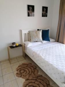 a bedroom with a white bed with a rug at Country Block-Holiday home in Kgaphamadi