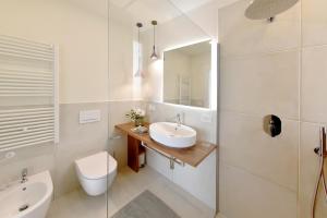 een badkamer met een wastafel, een toilet en een spiegel bij Relais Ulivo Ariana in Gaeta