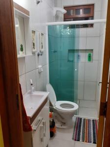 y baño con aseo y ducha acristalada. en Casa praia 4 quartos Sul da Ilha Florianópolis, en Florianópolis