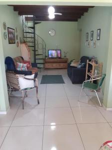 una sala de estar con sofás y TV en una habitación en Casa praia 4 quartos Sul da Ilha Florianópolis, en Florianópolis