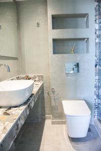 a bathroom with a white toilet and a sink at domus hospitality in Vourvourou