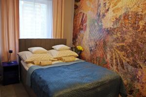 a bedroom with a bed with a painting on the wall at Apartament Mech & Paprocie in Ustrzyki Dolne