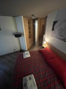 - une chambre avec un grand lit et une couverture rouge dans l'établissement Ski Paradise, à Breuil-Cervinia