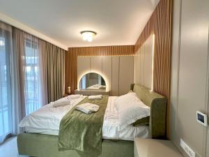 a bedroom with a large bed and a mirror at Luxury Apartment Amber - with jacuzzi in Kožino