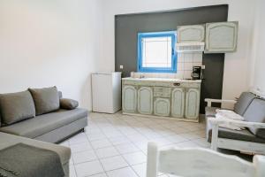 a living room with a couch and a kitchen at Villa Marina in Perdika