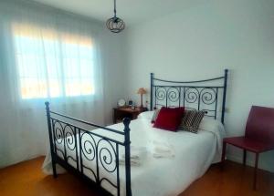 um quarto com uma cama grande e uma cadeira vermelha em Cerca de la playa, con bodega, terraza y jardin Camino Portugués em A Guarda