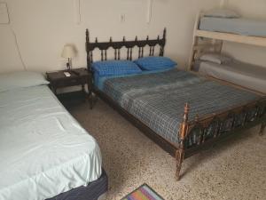 a bedroom with two twin beds and a night stand with a bedskirts at Hotel Hostal Caballito Blanco in Santa Fe