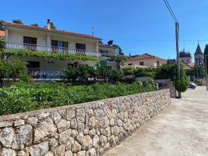 a stone retaining wall in front of a house at Holiday home Mandi in Vrbanj