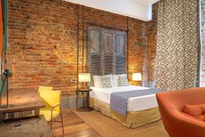 a bedroom with a bed and a brick wall at Selina Lapa Rio de Janeiro in Rio de Janeiro
