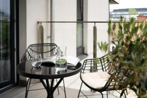 a black table and chairs on a balcony at Unique & Modern Apartment Zabłocie in Kraków