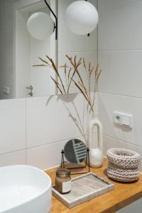 a bathroom with a sink and a vase on a counter at Unique & Modern Apartment Zabłocie in Krakow