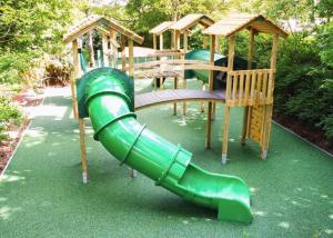 un parque infantil con un tobogán verde y una estructura de juegos de madera en Lee Valley Sewardstone, en Enfield Lock