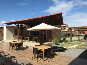 d'une terrasse avec des tables, des chaises et un parasol. dans l'établissement Excelente apartamento Villamares, à Luis Correia