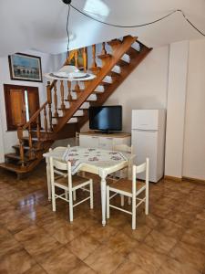une salle à manger avec une table, des chaises et un escalier dans l'établissement Casa Ronci - Centro Storico - Palacongressi Rimini, à Rimini