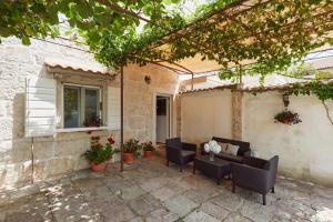 a patio with chairs and a table and a window at Konoba 224 Apartments in Kotor