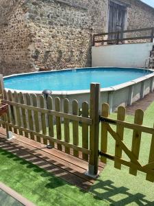 a large swimming pool with a wooden fence around it at Lovely French Farmhouse with Private Swimming Pool in Bourganeuf
