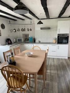 a kitchen with a table and chairs and a kitchen with white cabinets at Lovely French Farmhouse with Private Swimming Pool in Bourganeuf