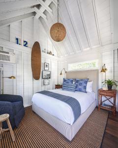 um quarto com uma cama grande e uma cadeira em Wanderer Cottages em Kennebunk