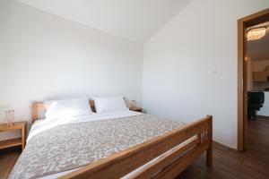 - une chambre avec un grand lit et des draps blancs dans l'établissement Apartments Miky, à Vrsi