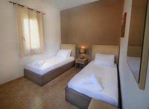 two beds in a small room with a window at Villa Silvia by Andrian Villas in Kalamítsion Alexándrou +22 photos