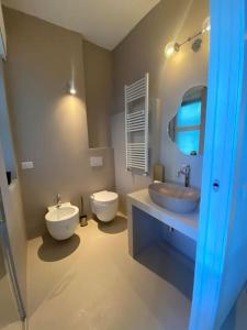Un baño con dos lavabos, un inodoro y un espejo. en Monolocale Scalo di Porta Romana, en Milán