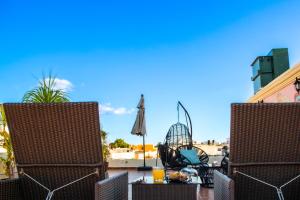 a patio with two chairs and an umbrella at Maya Campeche Hotel in Campeche