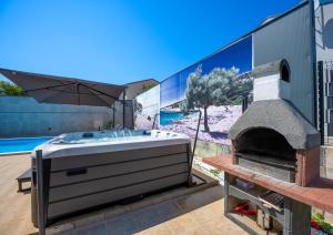 een bad naast een buitenoven bij Villa Beauty with heated pool and jacuzzi in Kanfanar