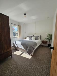 a bedroom with a large bed and a window at Ravensworth Cottage in Ravensworth