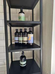 a shelf with four bottles of alcohol on it at Ravensworth Cottage in Ravensworth