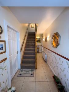 una escalera en una casa con una puerta blanca en Clare Forest Apartment, en Ballycastle