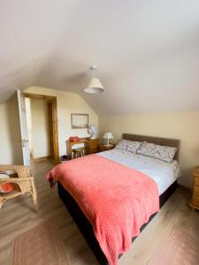 a bedroom with a bed with a red blanket at Clare Forest Apartment in Ballycastle