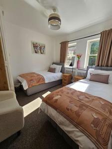una camera d'albergo con due letti e un divano di Ravensworth Cottage a Ravensworth