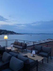 a deck with couches and tables and a view of the water at la petit maisonette de manu in Cannes