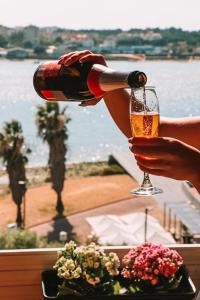 une personne détient un verre de vin dans l'établissement Golden Place - Seixal, à Arrentela