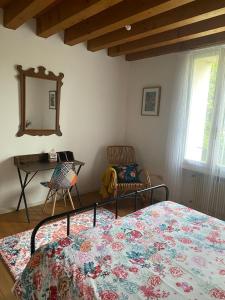 a bedroom with a bed and a desk and a mirror at Al Rustico in Bassano del Grappa