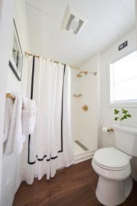 a white bathroom with a toilet and a shower at Wanderer Cottages in Kennebunk