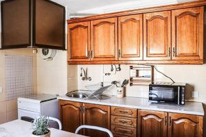 a kitchen with wooden cabinets and a microwave at Golden Place - Seixal in Arrentela