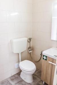 La salle de bains est pourvue de toilettes blanches et d'un lavabo. dans l'établissement Golden Place - Seixal, à Arrentela