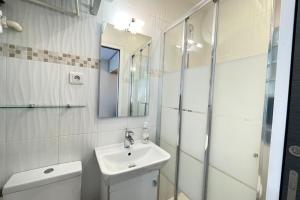 een badkamer met een wastafel, een toilet en een spiegel bij Appart'Village Jouy Vallée N4RER C500m Netflix in Jouy-en-Josas